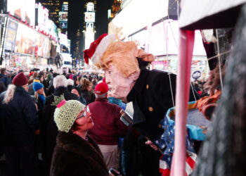 Na Times Square w Nowym Jorku mężczyzna w masce Donalda Trumpa spogląda na kobietę podczas wiecu poparcia  impeachmentu Donalda Trumpa. Fot. PAP/EPA/JUSTIN LANE