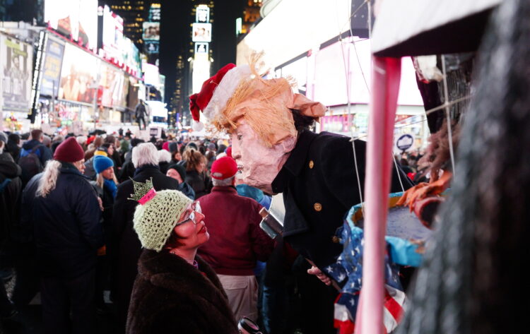 Na Times Square w Nowym Jorku mężczyzna w masce Donalda Trumpa spogląda na kobietę podczas wiecu poparcia  impeachmentu Donalda Trumpa. Fot. PAP/EPA/JUSTIN LANE