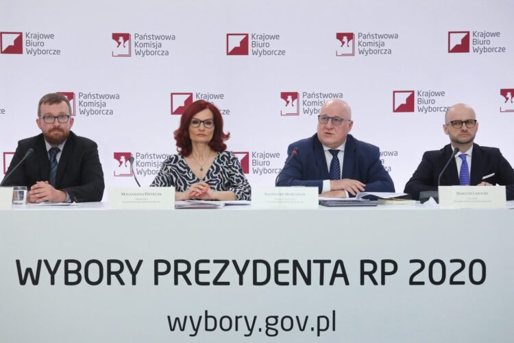 Wybory prezydenckie 2020 - II tura. Przewodniczący Państwowej Komisji Wyborczej Sylwester Marciniak (2P), członkowie PKW Arkadiusz Pikulik (L) i Dariusz Lasocki (P) oraz szefowa Krajowego Biura Wyborczego Magdalena Pietrzak (2L) podczas konferencji prasowej PKW w Warszawie, 12 bm. dot. rozpoczęcia i przebiegu głosowania. Fot. PAP