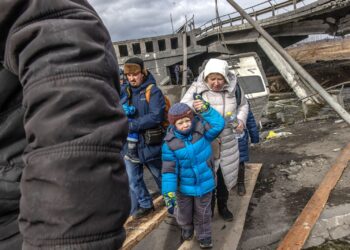 Ludzie przechodzą przez zniszczony most, uciekając z frontowego miasta Irpin, obwód kijowski, Ukraina, 7 marca 2022 r. Fot. PAP/EPA/ROMAN PILIPEY