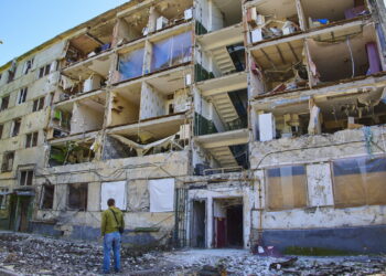 Mężczyzna patrzy na budynek mieszkalny uszkodzony podczas ostrzału Charkowa na Ukrainie, 12 maja 2022 r. Fot. PAP/EPA KOZLOVSERGEY