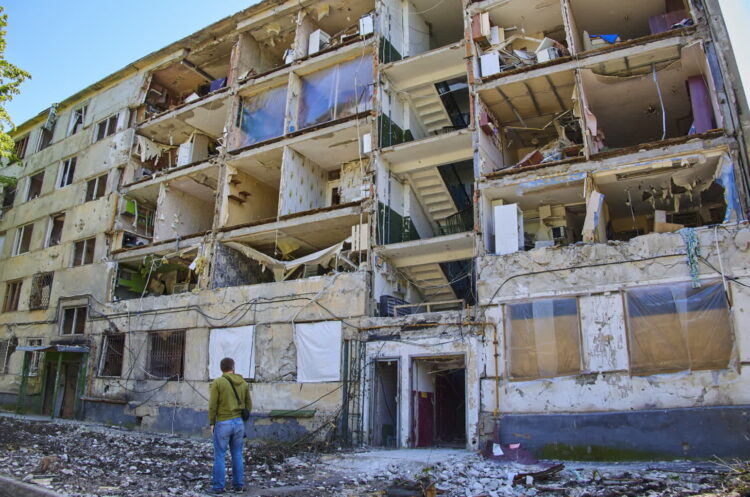 Mężczyzna patrzy na budynek mieszkalny uszkodzony podczas ostrzału Charkowa na Ukrainie, 12 maja 2022 r. Fot. PAP/EPA KOZLOVSERGEY