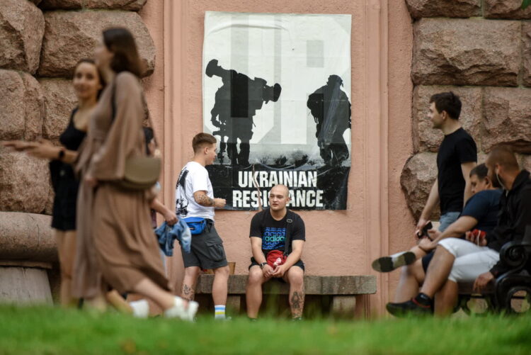 Ludzie w pobliżu antywojennego plakatu w centrum Kijowa na Ukrainie, 3 lipca 2022 r. Fot. PAP/EPA/OLEG PETRASYUK