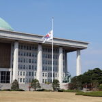 Flagi przed budynkiem Zgromadzenia Narodowego dzień po śmiertelnym panice w dzielnicy Itaewon podczas obchodów Halloween, w Seulu w Korei Południowej, 30 października 2022 r. Fot. PAP/EPA/YONHAP