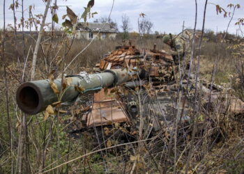 Żołnierz ukraińskiej Gwardii Narodowej bada zniszczony czołg w nieujawnionym miejscu w rejonie Charkowa, północno-wschodnia Ukraina, 25 października 2022 r. Fot. PAP/EPA/SERGIY KOZLOV
