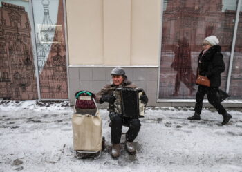Mężczyzna zarabia na życie grając na akordeonie na ulicy podczas opadów śniegu w Moskwie, Rosja, 18 listopada 2022 r. Fot. PAP/EPA/YURI KOCHETKOV