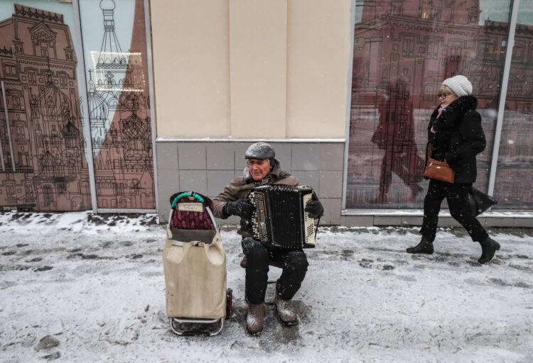 Mężczyzna zarabia na życie grając na akordeonie na ulicy podczas opadów śniegu w Moskwie, Rosja, 18 listopada 2022 r. Fot. PAP/EPA/YURI KOCHETKOV