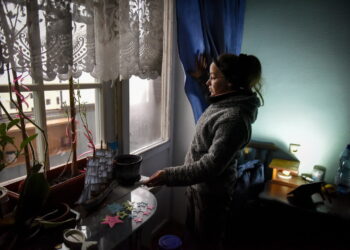 Tetiana pokazuje działanie lampy ładującej się z panelu słonecznego w swoim mieszkaniu w zniszczonym bloku mieszkalnym w Horence koło Kijowa, Ukraina, 03 grudnia 2022 r. Fot. PAP/EPA/OLEG PETRASYUK
