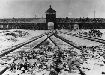 Wjazd do Auschwitz, nazistowskiego obozu koncentracyjnego i obozu śmierci prowadzonego przez nazistowskie Niemcy na terenie Polski w latach 1940–1945 (1945 r). Zdjęcie: Wikimedia Commons (Niemieckie Archiwa Państwowe).