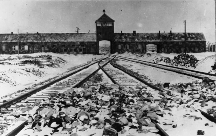Wjazd do Auschwitz, nazistowskiego obozu koncentracyjnego i obozu śmierci prowadzonego przez nazistowskie Niemcy na terenie Polski w latach 1940–1945 (1945 r). Zdjęcie: Wikimedia Commons (Niemieckie Archiwa Państwowe).