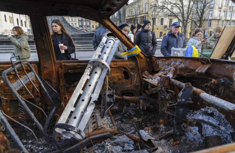 Ludzie we Lwowie oglądają zniszczone samochody przywiezione przez ochotników z linii frontu pod Bachmutem, 03 stycznia 2023 r. Fot. PAP/EPA/MYKOLA TYS