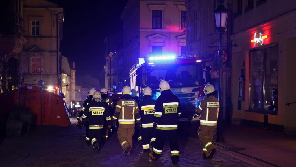 Strażacy w drodze na akcję poszukiwawczo-ratowniczą w miejscu zawalonej kamienicy przy ulicy Głębokiej w centrum Cieszyna Fot. PAP/Jarek Praszkiewicz