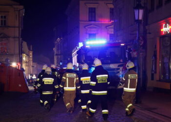 Strażacy w drodze na akcję poszukiwawczo-ratowniczą w miejscu zawalonej kamienicy przy ulicy Głębokiej w centrum Cieszyna Fot. PAP/Jarek Praszkiewicz