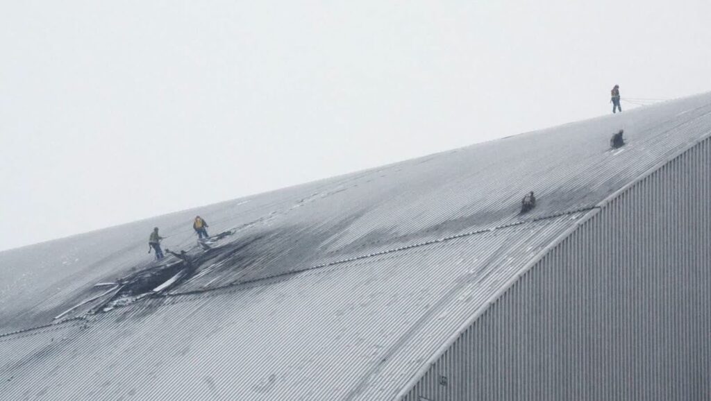 Pracownicy oglądają zniszczenia sarkofagu nad zniszczonym reaktorem w Czarnobylu Fot. PAP/EPA/SERGEY DOLZHENKO