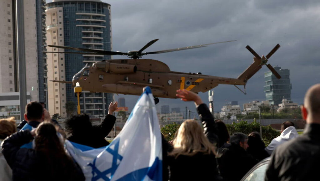 Wojskowy helikopter przewozi uwolnionego izraelskiego zakładnika. Fot. PAP/EPA/ ATEF SAFADI