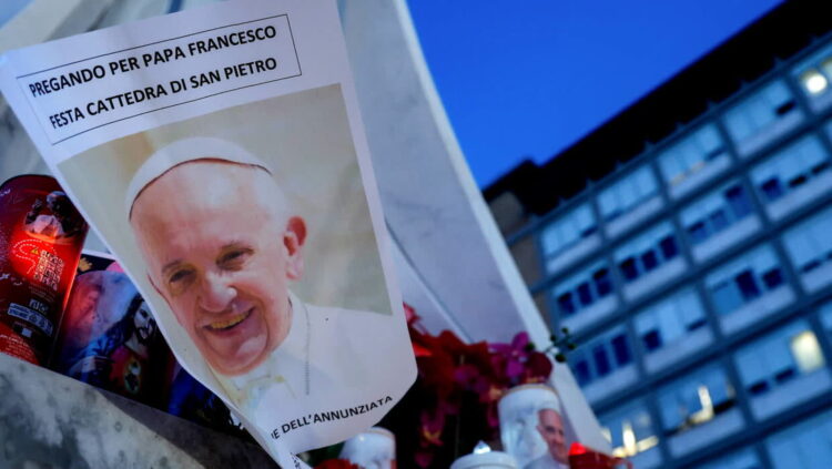 Świece pod pomnikiem Jana Pawła II przy wejściu do szpitala Gemelli, w którym przebywa papież Franciszek. Fot. PAP/EPA/ GIUSEPPE LAMI