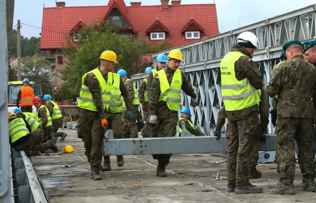 Koniec operacji Fenix. Wojsko zostaje na terenach popowodziowych 2 Żołnierze z wojsk inżynieryjnych montują konstrukcję mostu nad Białą Głuchołaską w Głuchołazach. Fot. PAP/Krzysztof Świderski