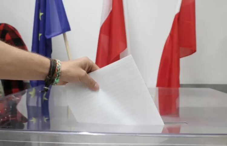 Uczestnik wyborów wrzuca głos do urny Fot. PAP/Tomasz Gzell