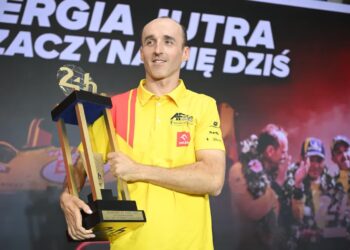 Kierowca zespołu AF Corse Robert Kubica pozuje do zdjęcia z trofeum podczas briefingu prasowego w Warszawie, fot. PAP/Marcin Obara
