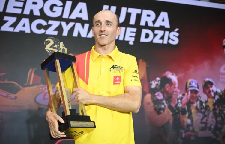 Kierowca zespołu AF Corse Robert Kubica pozuje do zdjęcia z trofeum podczas briefingu prasowego w Warszawie, fot. PAP/Marcin Obara