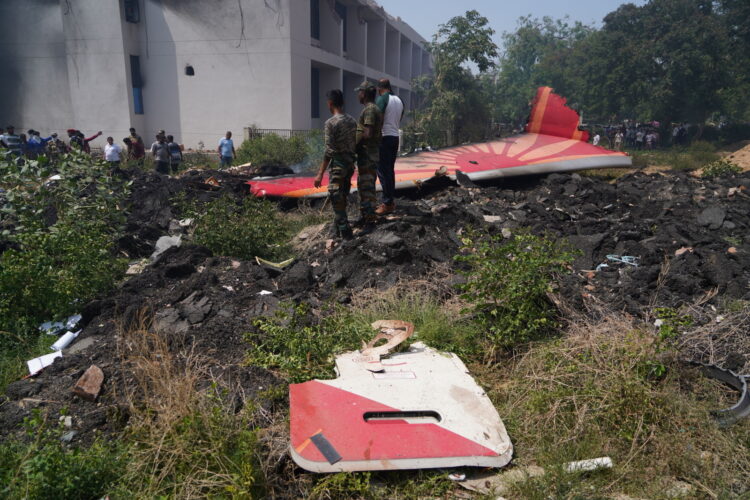 epa12171233 People stand near debris at the site of a plane crash near Sardar Vallabhbhai Patel International Airport in Ahmedabad, Gujarat, western India, 12 June 2025. Air India flight AI171, bound for London carrying 242 passengers and crew members on board a Boeing 787-8 aircraft, crashed minutes after take-off in the Meghaninagar area of Ahmedabad.  EPA/SIDDHARAJ SOLANKI 
Dostawca: PAP/EPA.