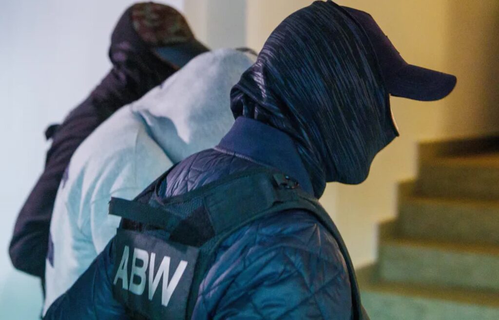 Zarzuty dla pięciu osób za działania na rzecz obcego wywiadu. Trzy osoby trafiły do aresztu 3 Funkcjonariusze ABW prowadzący zatrzymanego. Fot. PAP/Krzysztof Ćwik