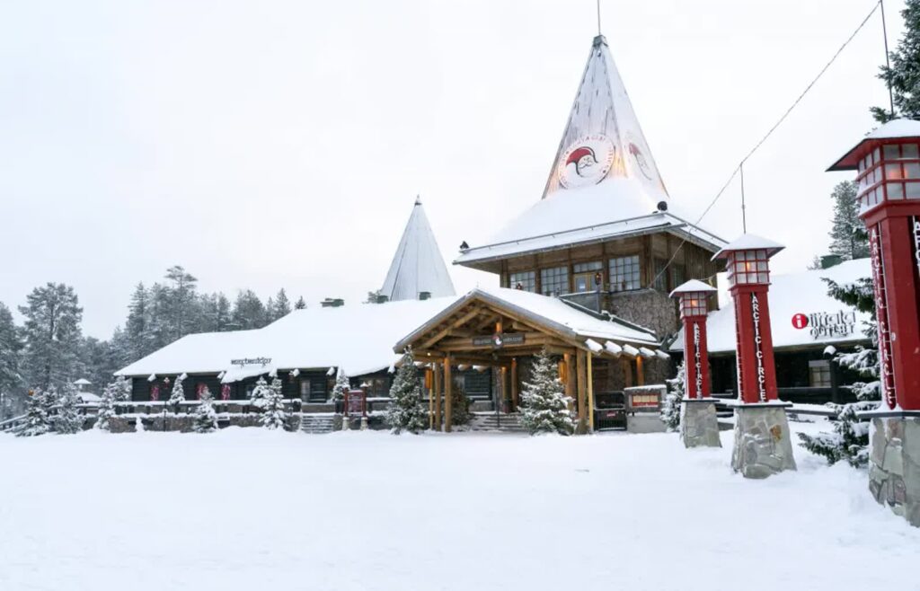 Pokryta śniegiem pusta ulica w wiosce Świętego Mikołaja na kole podbiegunowym, niedaleko Rovaniemi w Finlandii. Fot. EPA/KAISA SIREN