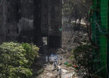 Służby i strażacy podczas prac na miejscu pogorzeliska, fot. PAP/EPA/LEUNG MAN HEI