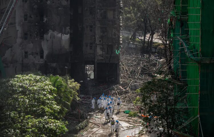 Służby i strażacy podczas prac na miejscu pogorzeliska, fot. PAP/EPA/LEUNG MAN HEI