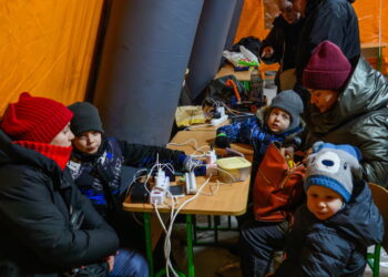 Mieszkańcy Kijowa gromadzą się w ogrzewanym namiocie, w którym można także doładować urządzenia elektroniczne. Fot. PAP/Vladyslav Musiienko