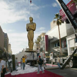 Dźwig ustawia 21 bm. gigantyczną statuetkę Oskara przed wejściem do teatru Kodaka w Hollywood, 2002 r. Fot. PAP/EPA GERARD BURKHART