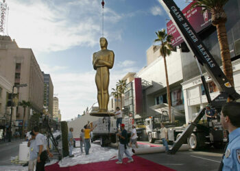 Dźwig ustawia 21 bm. gigantyczną statuetkę Oskara przed wejściem do teatru Kodaka w Hollywood, 2002 r. Fot. PAP/EPA GERARD BURKHART