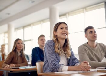 Happy female student and her friends having a class at the university,