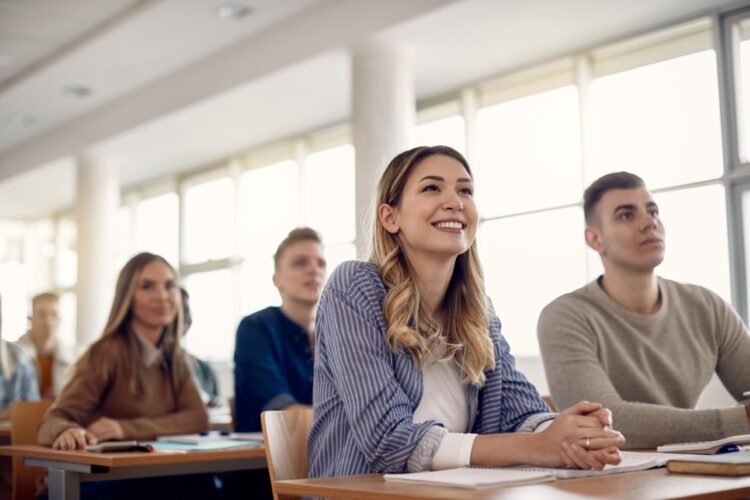 Happy female student and her friends having a class at the university,