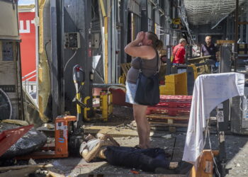 Ukrainka przy ciele ofiary rosyjskiego ataku na terminal pocztowy Nowej Poczty w Charkowie z 19 lipca 2026r. Fot. PAP/EPA/SERGEY KOZLOV