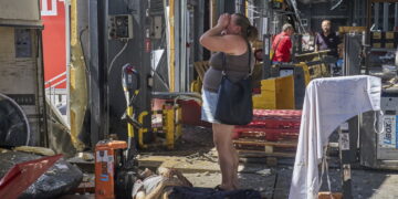 Ukrainka przy ciele ofiary rosyjskiego ataku na terminal pocztowy Nowej Poczty w Charkowie z 19 lipca 2026r. Fot. PAP/EPA/SERGEY KOZLOV