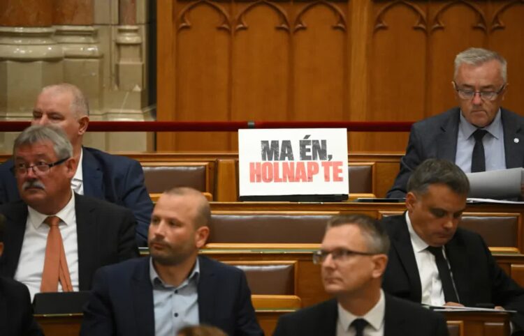 Na miejscu posła Miklosa Sesztaka w Zgromadzeniu Narodowym w Budapeszcie, widnieje plakat z napisem „Dzisiaj ja, jutro ty”. Sesztak został zatrzymany w budapeszteńskiej siedzibie Centralnej Prokuratury Śledczej Fot. PAP/EPA/Boglarka Bodnar